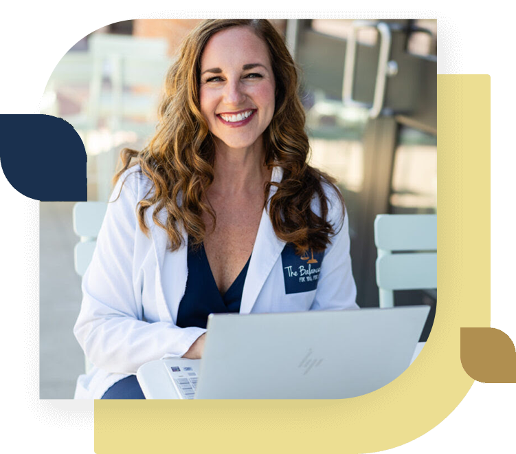 Owner nurse practitioner with computer closer in and white lab coat, decorative design for The Balanced Life